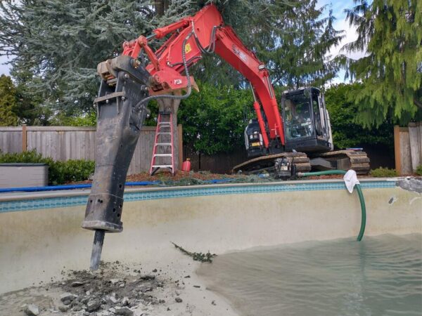 Excavator demolishing a swimming pool