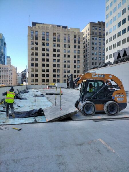 Construction site with worker and skid steer loader