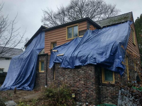 House under renovation covered with blue tarps