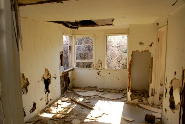 Abandoned room with peeling walls and sunlight entering