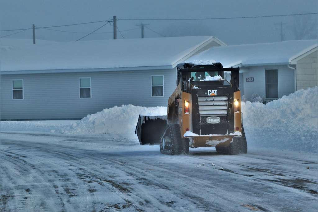 Snowplow clearing street during heavy snowfall