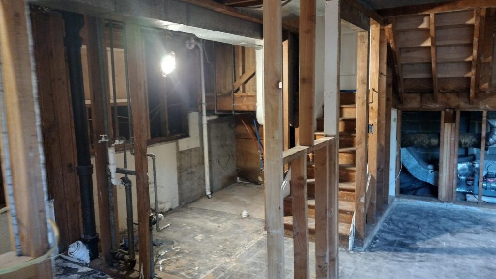 Exposed interior framing and plumbing of a house under renovation