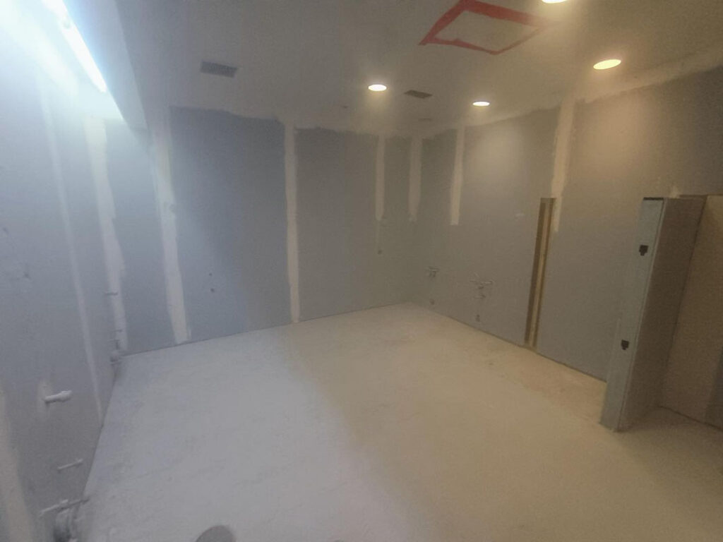 Unfinished interior room with drywall and exposed plumbing